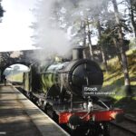 Steam engine standing at the platform at Cheltenham Racecourse Station to Winchcombe on the Gloucestershire Warwickshire Railway in the shadows of a late autumn day. Locomotive is an ex-GWR 28xx Class 2-8-0, 2807.